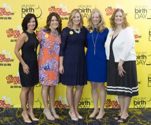 The Healthy Birth Day, Inc. founders stand in front of a yellow backdrop