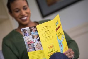 Black woman reads bright yellow Count the Kicks brochure