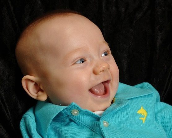 Baby Save Cooper smiles and wears a light blue polo shirt