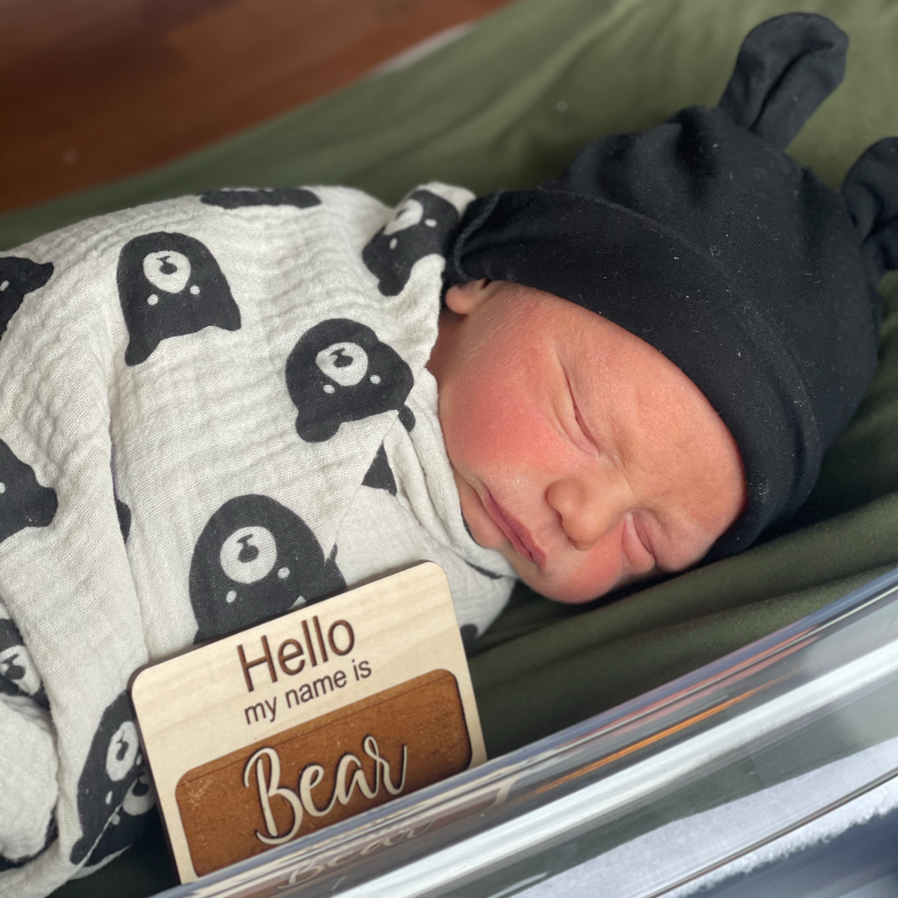 Baby Bear wears a bear hat and is wrapped in a bear swaddle.