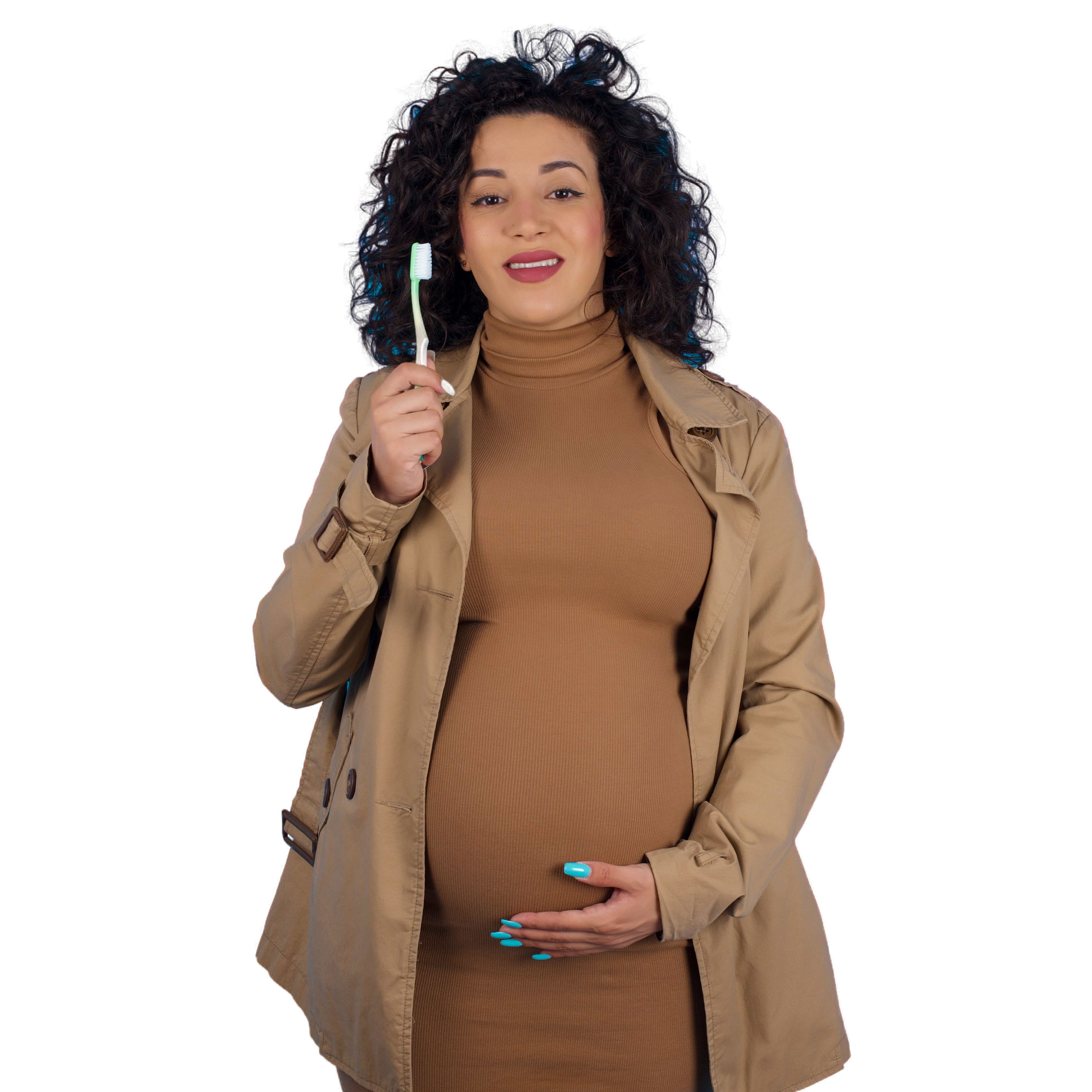 Pregnant Black woman brushing teeth