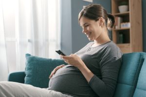 A pregnant woman using the Count the Kicks app to track her baby's movement.