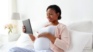 Pregnant Black woman using Count the Kicks on her iPad