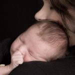 Baby save William snuggles on his mom's shoulder