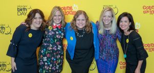 The Healthy Birth Day, Inc. Founders stand in front of a yellow backdrop