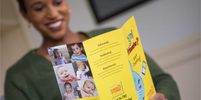 Black woman reads bright yellow Count the Kicks brochure