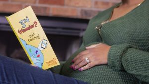 An expectant mom reads a Count the Kicks brochure.