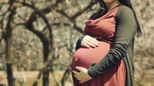 Pregnant woman holding her belly.