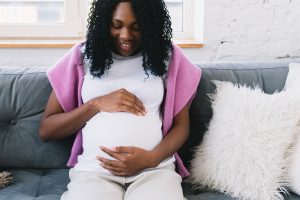 Pregnant woman looks at her belly and bonds with her baby