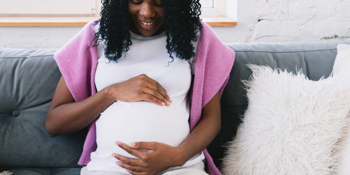 Pregnant woman looks at her belly and bonds with her baby