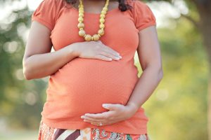 Pregnant woman resting her hands on her belly