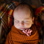 A peaceful baby sleeps in a woven basket